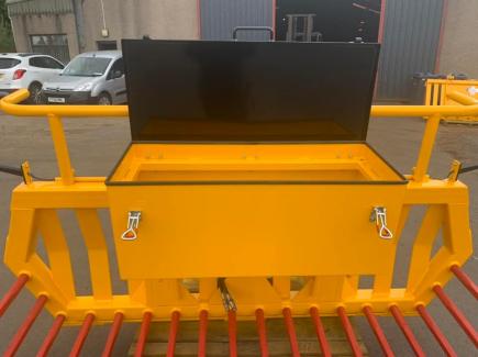 Hydraulic tipping stone fork with tool/weight box